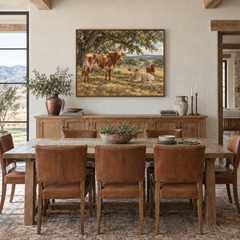 Longhorns beneath the Live Oaks displayed above an oak sideboard in a sunlit dining room