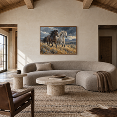 Windbreak oil painting of a dark and a pale horse running through windswept grass displayed in a ranch living room