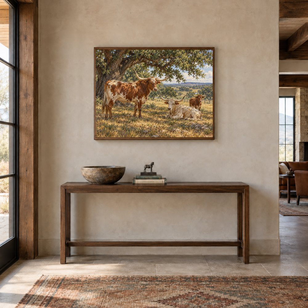 Longhorns beneath the Live Oaks displayed above a walnut console in a bright entryway