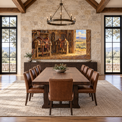 Saddles by the Open Door above a long table in a limestone and leather dining room